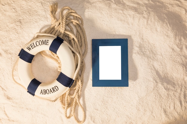 Empty frame and marine lifebuoy on sand