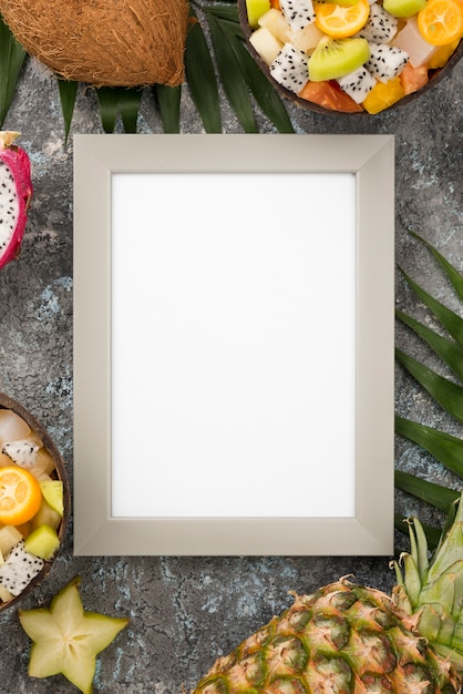 Free photo empty frame surrounded by exotic fruit