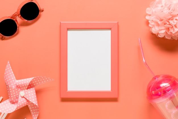 Empty frame with feminine stuff placed on red background