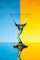 Free photo empty glass over blue and yellow wall