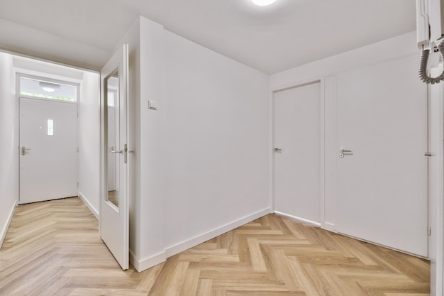 Empty interior area with white walls and laminate flooring