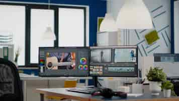 무료 사진 비디오 필름 몽타주 비디오 처리 기능이 있는 듀얼 모니터 설정이 있는 비어 있는 현대적인 크리에이티브 에이전시 사무실...