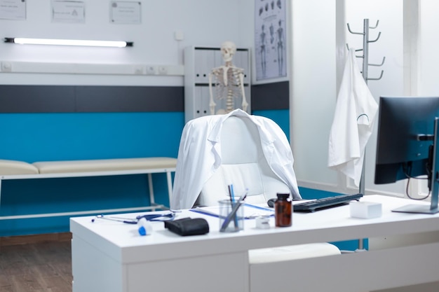 Empty modern medical office having disease documents on table equipped with contemporary furniture. Hospital workplace with nobody in it ready for sickness consultation. Medicine support