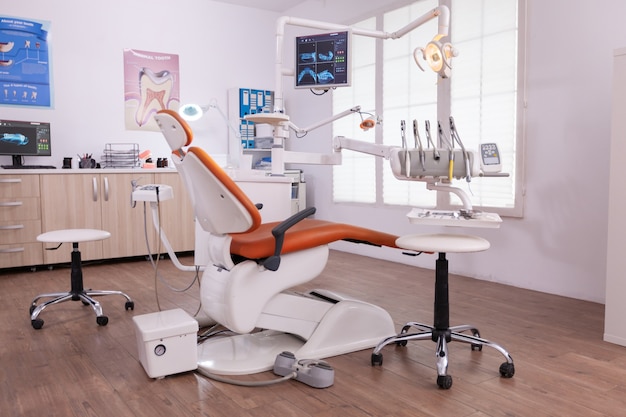 치과 교정 전문의 의료 치료를 위한 준비가 된 치과 기구를 갖춘 아무도 없는 비어 있는 현대적인 치아 관리 구강 병원 사무실. 디스플레이에 치아 방사선 이미지