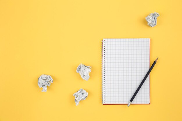 Empty notebook and crumpled paper balls flat lay