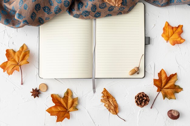 Empty notebook next to leaves and cloth