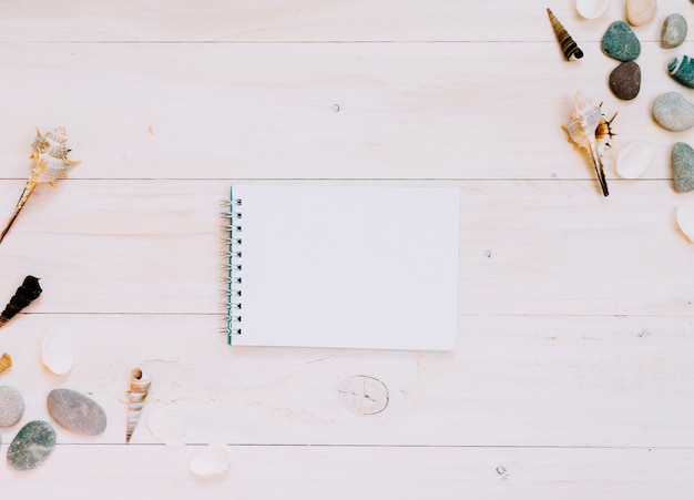 Empty notebook and marine items on striped surface