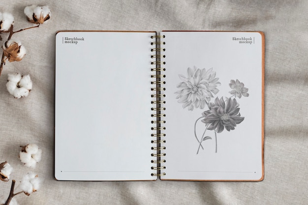 花の背景に空のノートブックページ