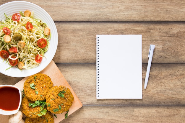 Empty notebook next to vegan food 