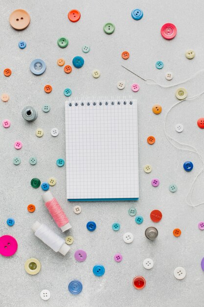 Empty notepad surrounded by haberdashery accessories