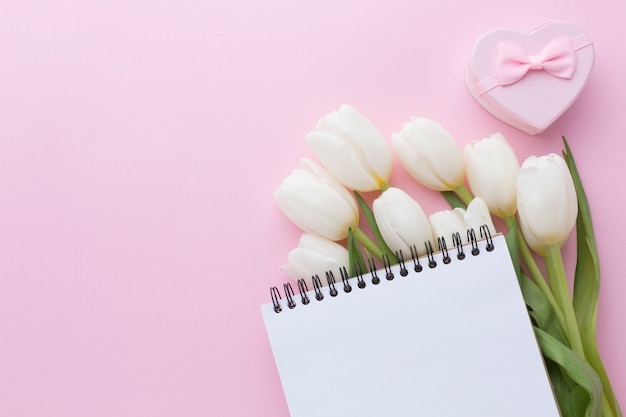 Empty notepad above tulip flowers