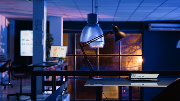 Empty office with analytics and diagrams on screen, running economy statistics on computers in business space. Startup company with research plans and charts, late at night. Handheld shot.