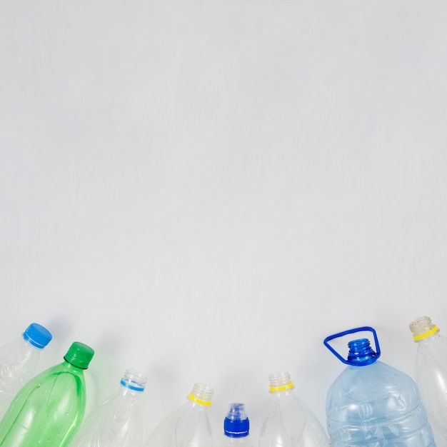 Empty plastic bottle at the bottom of white background