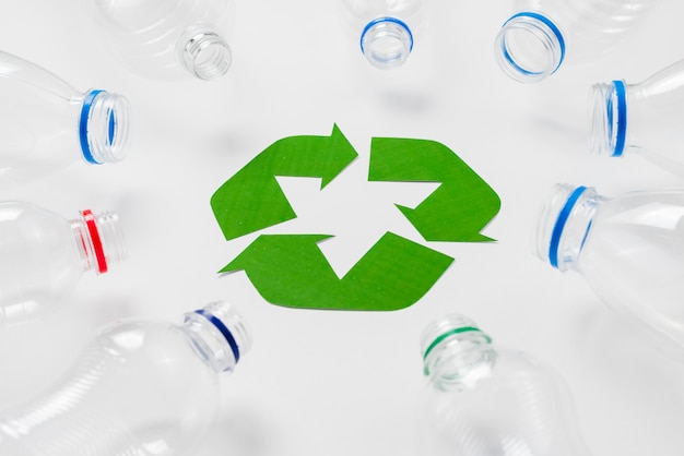Пустые пластиковые бутылки вокруг логотипа переработки