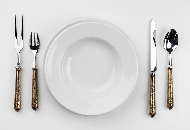 Пустая тарелка со столовыми приборами, изолированные на белом фоне