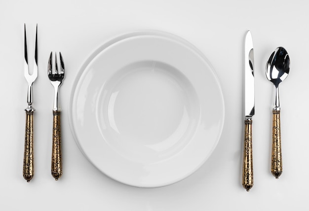 Empty plate with cutlery isolated on white background