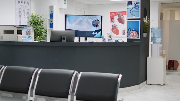 Empty reception counter and waiting room to attend medical appointment with general practitioner at healthcare facility. Hospital lobby seats at private clinic, checkup examination.