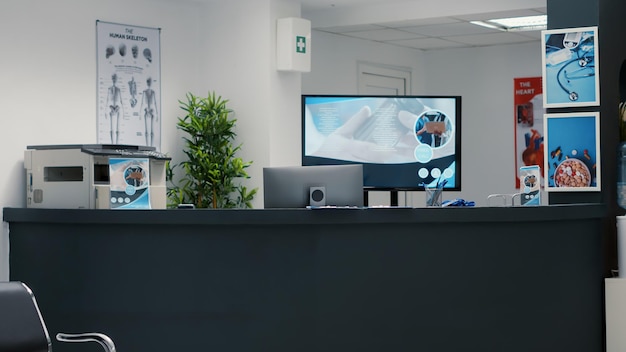 Empty reception desk for appointments at medical facility, waiting area with chairs to sit in rows before attending checkup consultation. Healthcare clinical space for emergency at center.