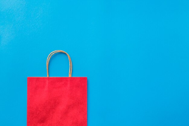 Empty red shopping bag on blue background