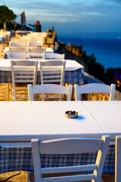 Afytos, 그리스의 거리에 테라스가있는 빈 레스토랑