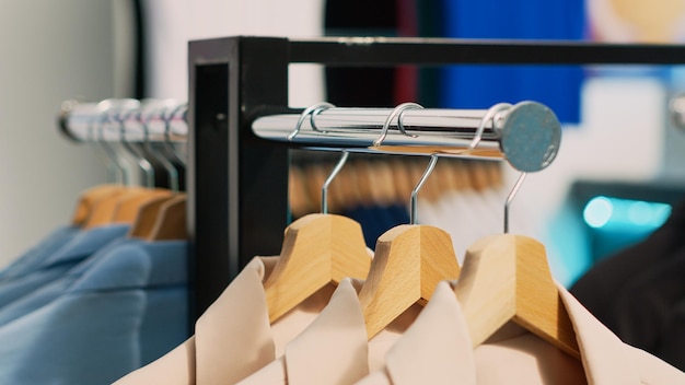 Free photo empty retail store filled with racks and hangers, modern casual wear hanging in shopping mall shop. fashionable boutique with clothes on sale, small business commercial activity concept.