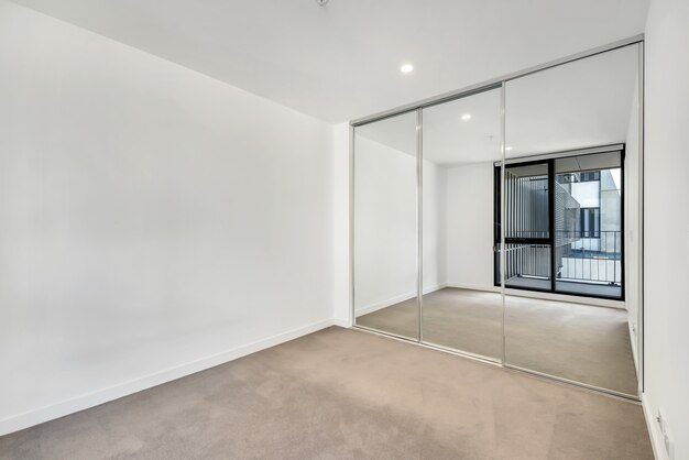 Empty room with the windows' reflection in the mirrored closet