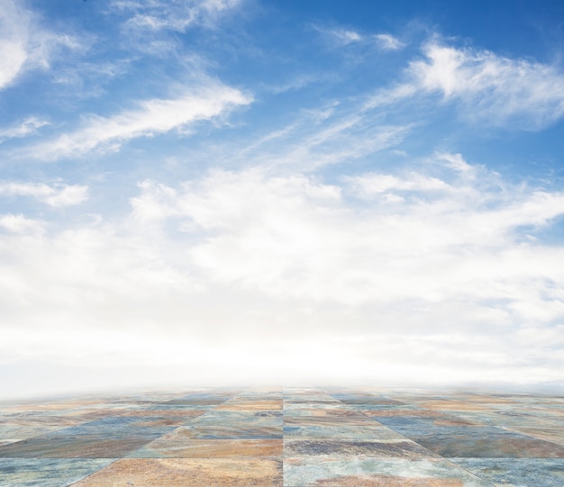 An empty scene of a stone tile floor and a blue sky