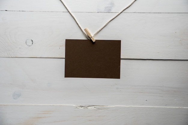 empty sign attached to a rope with a white wooden wall