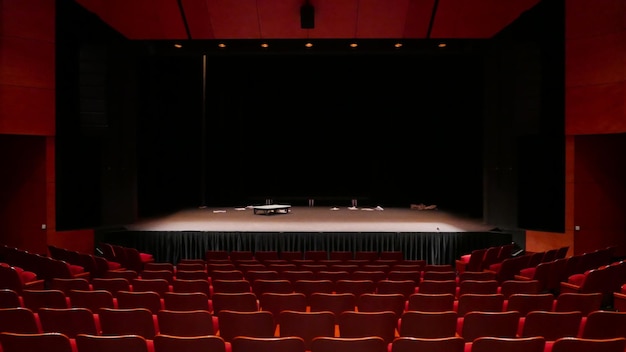 Empty stage with a few props and red seats