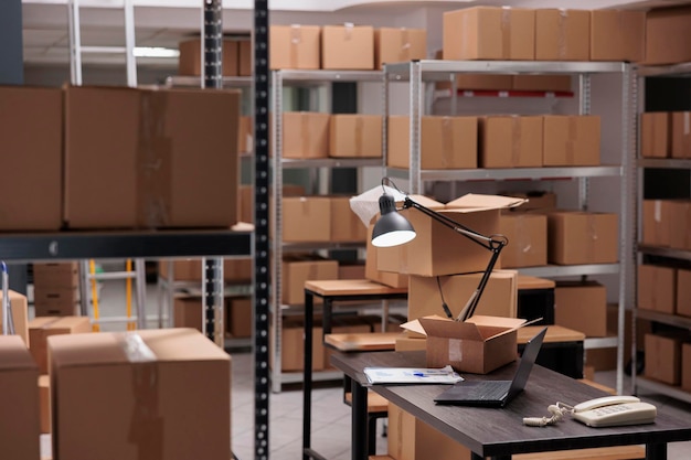 Empty storehouse delivery department with nobody in it full with rows of shelves with carton boxes, ready for workers to start preparing packages. Interior of heavy industry manufacturing factory.