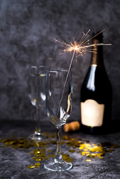 Empty transparent wine glass with christmas sparkler on cement concrete background