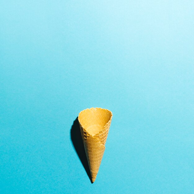 Empty waffle cone on blue background