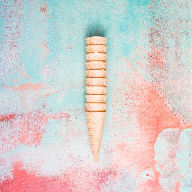 Empty waffle cones collecting into each other on colorful background