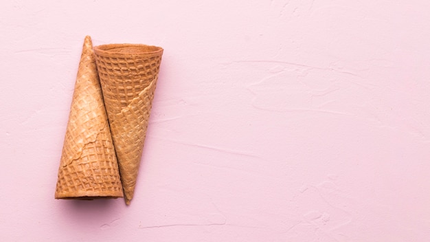 Empty waffle cones on pink background