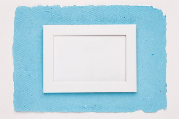 An empty white border frame on blue paper over white background