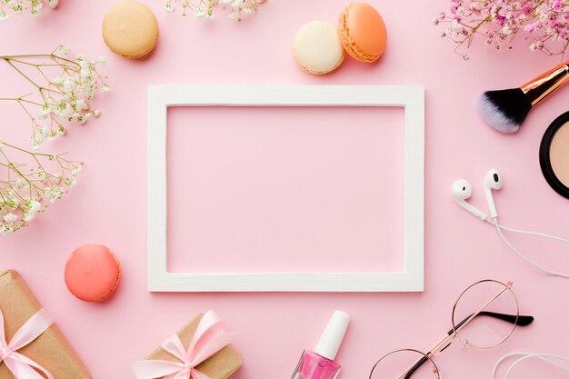 Empty white frame surrounded by make-up accessories