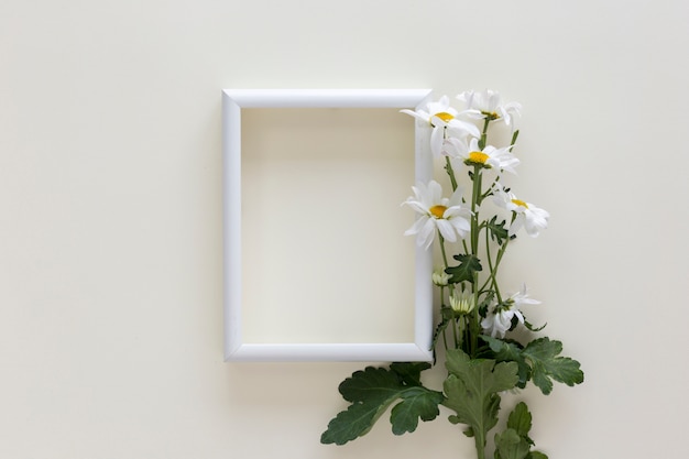 Empty white frame with flowers over isolated on white background