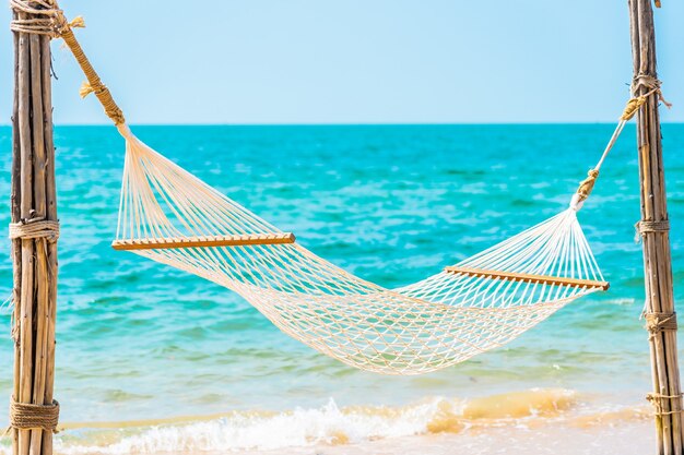 Empty white hammock around sea beach ocean for leisure travel vacation concept