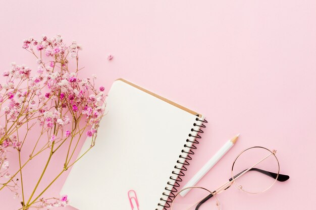 Empty white notepad and flowers flat lay