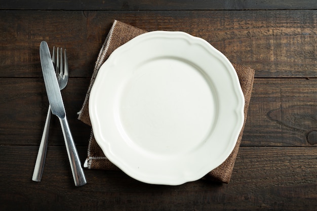 Бесплатное фото Пустая белая тарелка на деревянный стол.