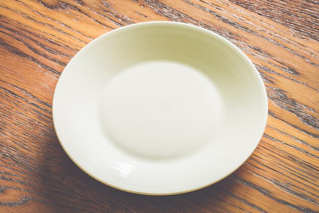 Empty white plate on wood background 