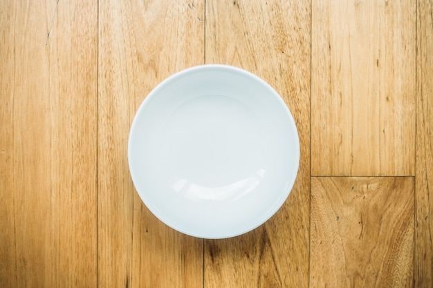 Empty white plate on wooden background