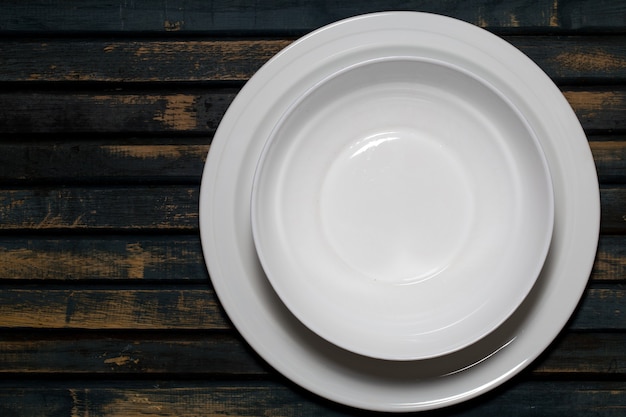 Empty white plates on a wooden table