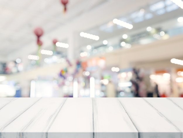 Empty white table top and blur shopping center in the background