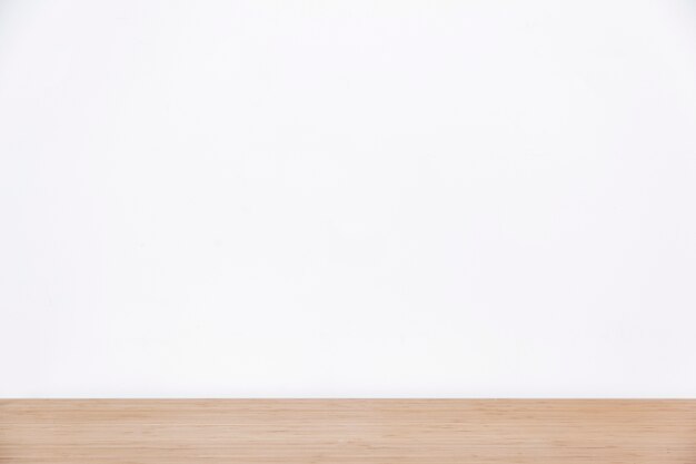 Empty white wall and wooden surface