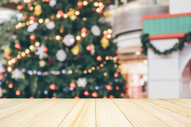 Empty wood table top with abstract blur christmas tree with decoration bokeh light background for product display