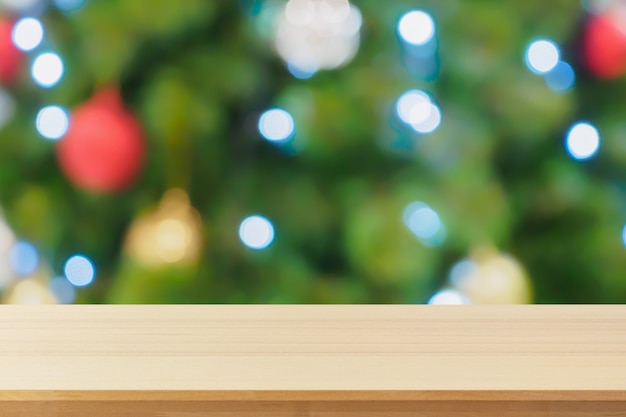 Empty wood table top with abstract blur christmas tree with decoration bokeh light background for product display