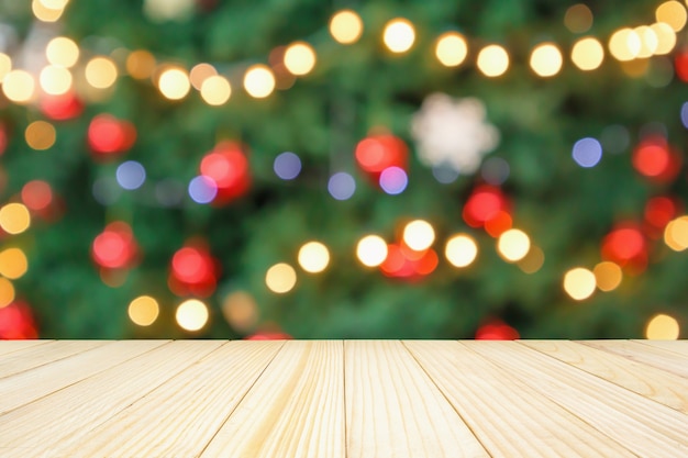 Empty wood table top with abstract blur christmas tree with decoration bokeh light background for product display