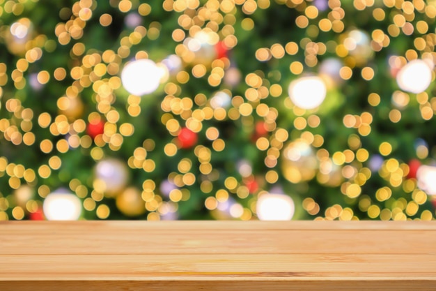 Empty wood table top with abstract blur christmas tree with decoration bokeh light background for product display