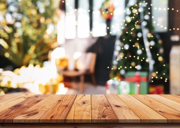 Empty wood table with decorated christmas tree with shiny lights  background blurred